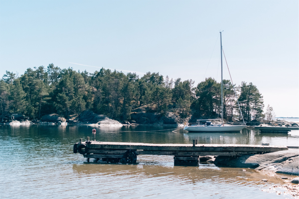 Brygge med seilbåt fortøyd i bakgrunnen