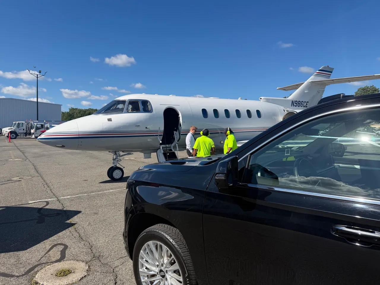 GeronimoLux chauffeur SUV waiting planeside next to a private jet