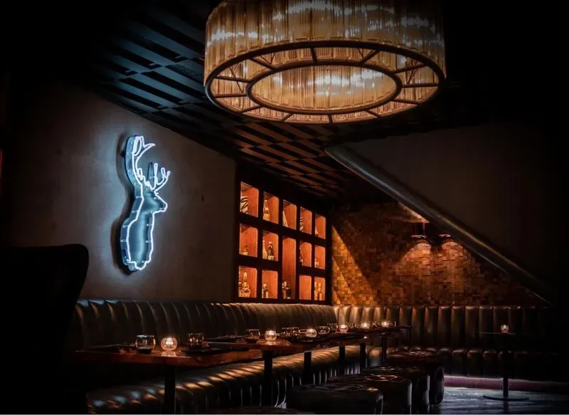 A vibrant restaurant illuminated by colorful neon lights, creating a lively and inviting atmosphere.