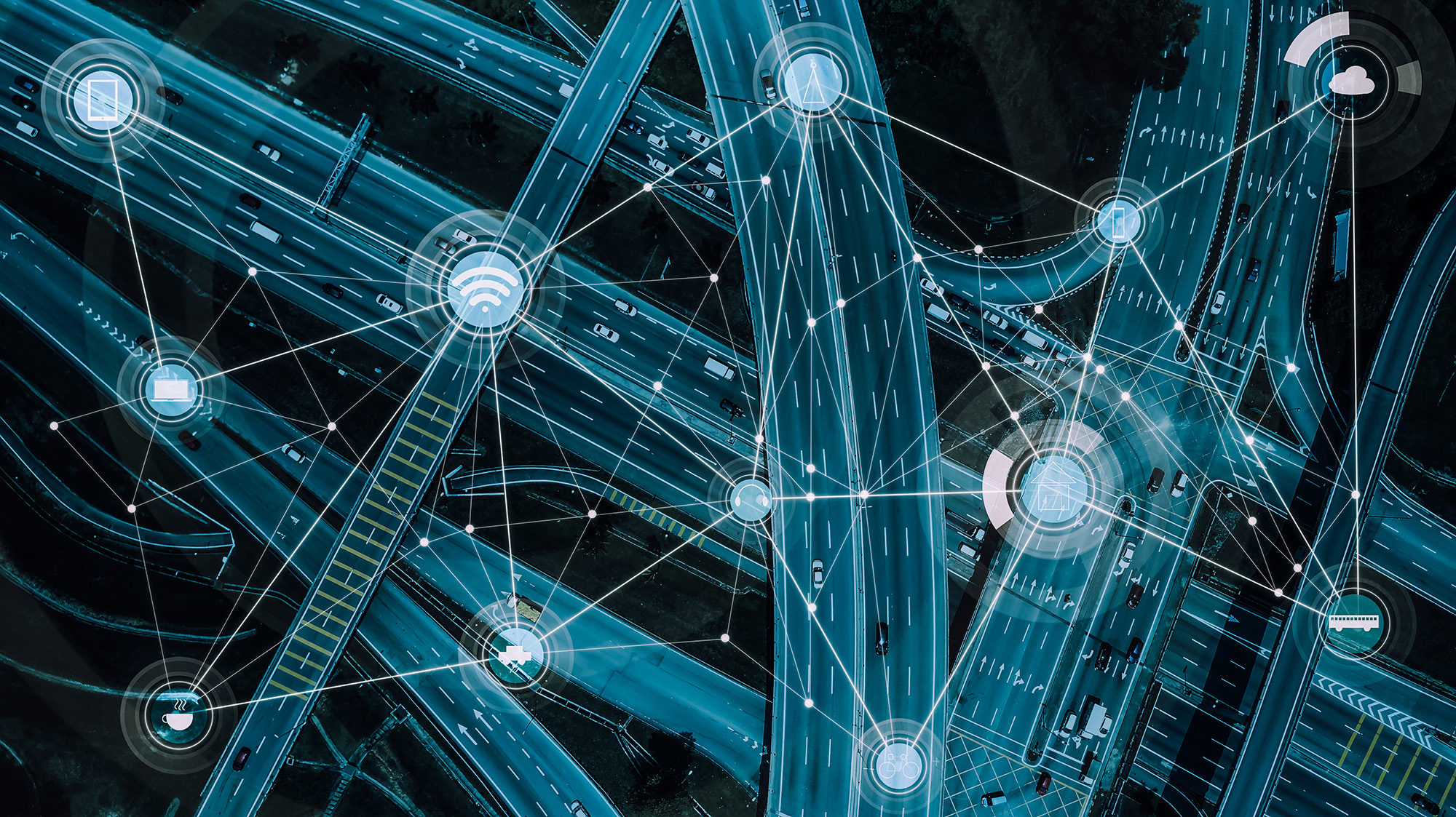 Aerial view of a complex highway interchange with digital network icons representing connectivity and communication.