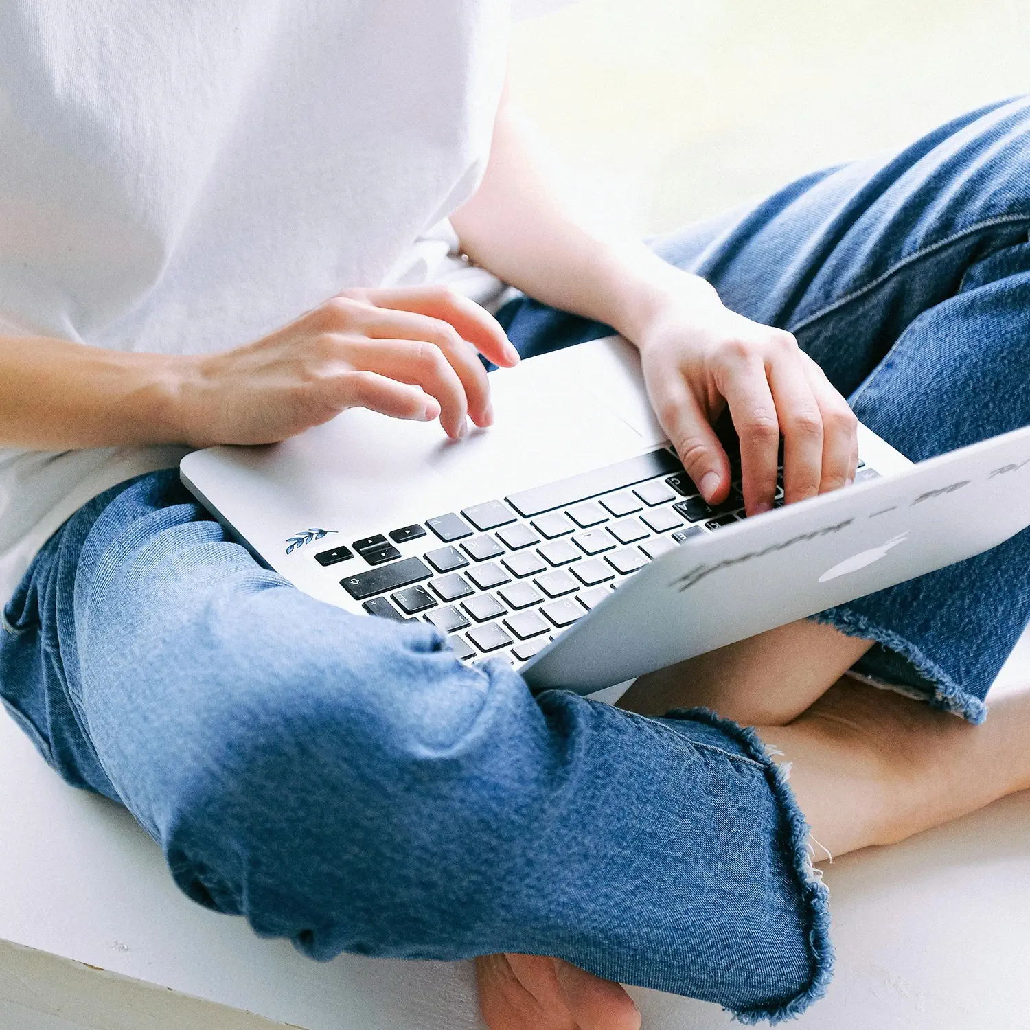 Flexibles Arbeiten und attraktive Privatnutzung: Eine Frau nutzt ein MacBook auf dem Schoß – das digitale Mitarbeiter-PC-Programm (MPP) von DVICE und der JobRad Gruppe bietet modernste IT-Hardware einfach per Gehaltsumwandlung.