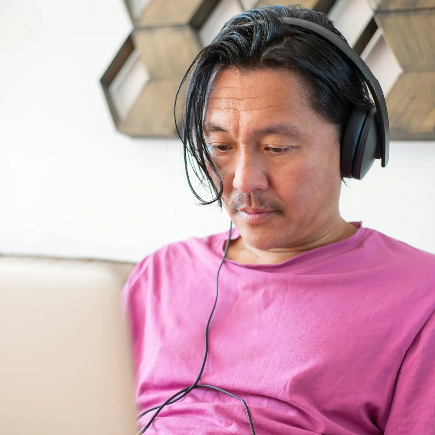 Fokussiertes Arbeiten mit moderner Ausstattung: Ein Mann nutzt Laptop und Kopfhörer von DVICE – das digitale Mitarbeiter-PC-Programm der JobRad Gruppe ermöglicht den Zugang zu hochwertiger Technologie als Benefit inklusive Rundum-Schutz und privater Nutzung.