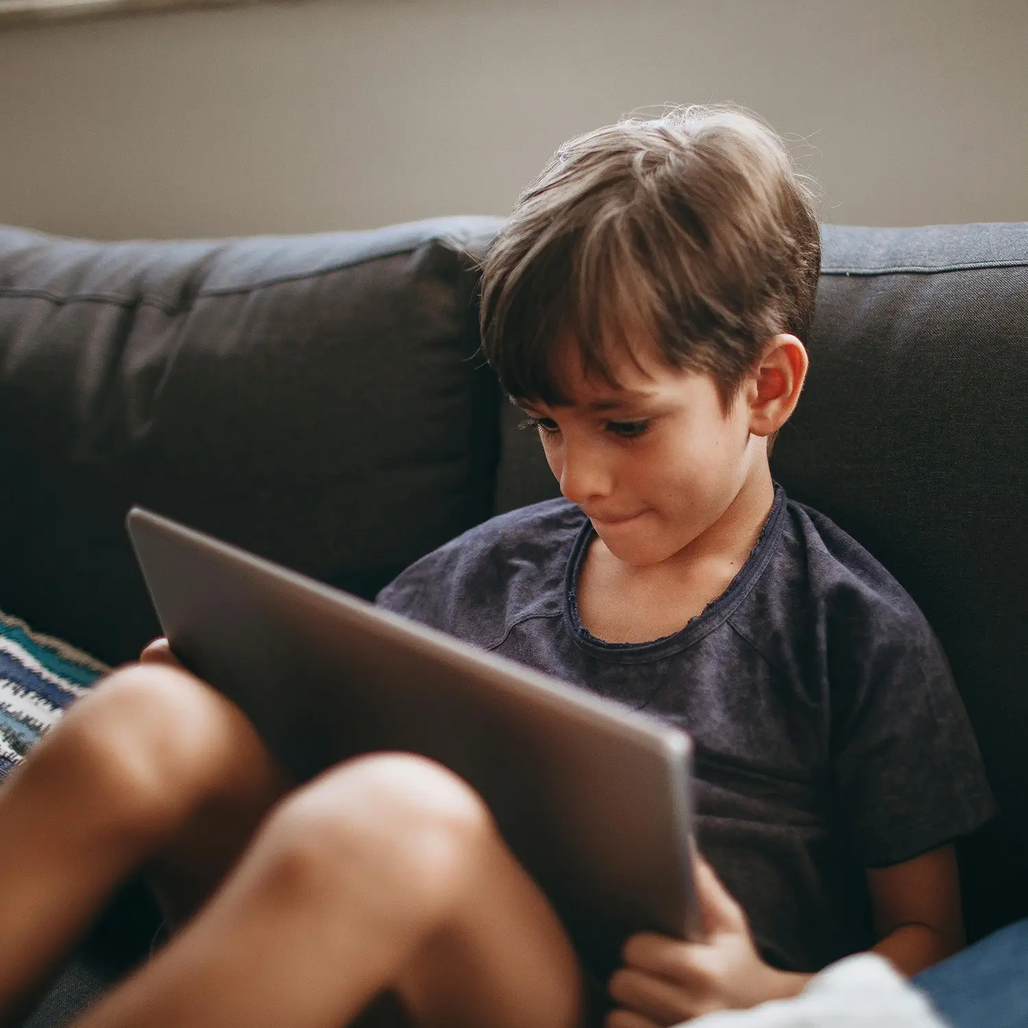 Technologie-Vorteile für die ganze Familie: Ein Junge nutzt ein Tablet zur privaten Unterhaltung – DVICE ermöglicht den Zugang zu modernster Technik als steuerfreien Arbeitgeber-Benefit.