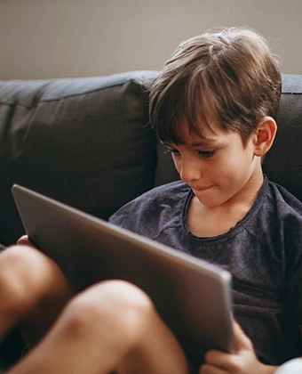 Technologie-Vorteile für die ganze Familie: Ein Junge nutzt ein Tablet zur privaten Unterhaltung – DVICE ermöglicht den Zugang zu modernster Technik als steuerfreien Arbeitgeber-Benefit.
