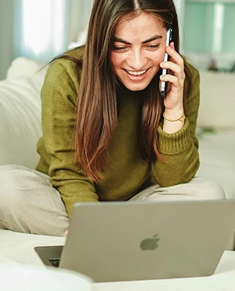Lächelnde Mitarbeiterin arbeitet mit einem Laptop und Tablet von DVICE: Das Mitarbeiter-PC-Programm der JobRad Gruppe ermöglicht den Zugang zu moderner IT-Hardware für produktives Arbeiten im Homeoffice.