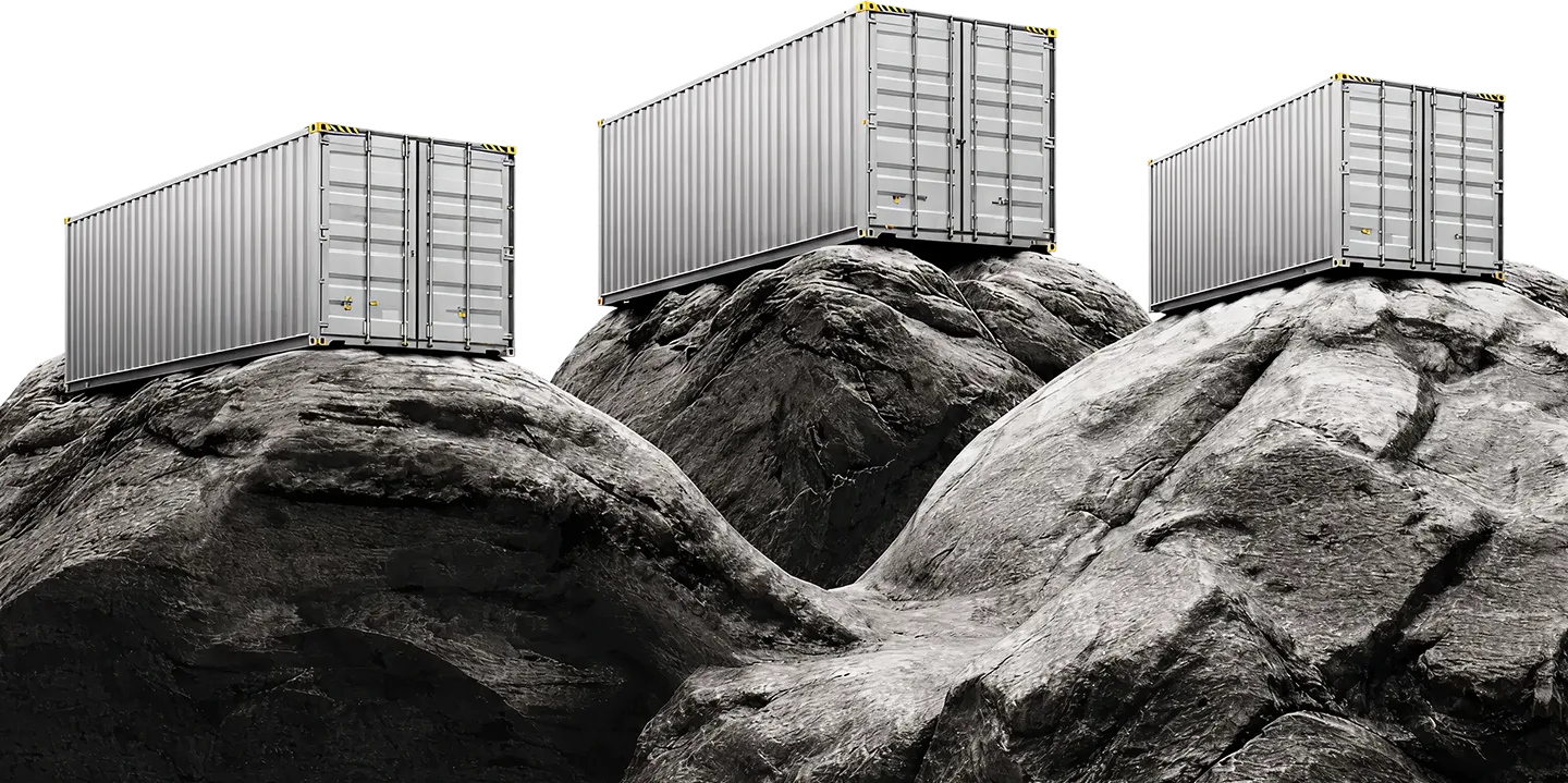 Three gray shipping containers placed on large rugged rocks against a black background.