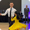 Man and woman performing a ballroom dance with the woman wearing a flowing yellow dress.