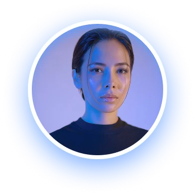 Close-up portrait of a woman with dark hair and a serious expression, illuminated by blue light on a light background.