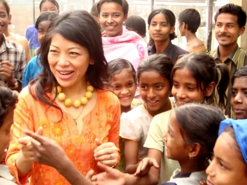 Aid working surrounded by children