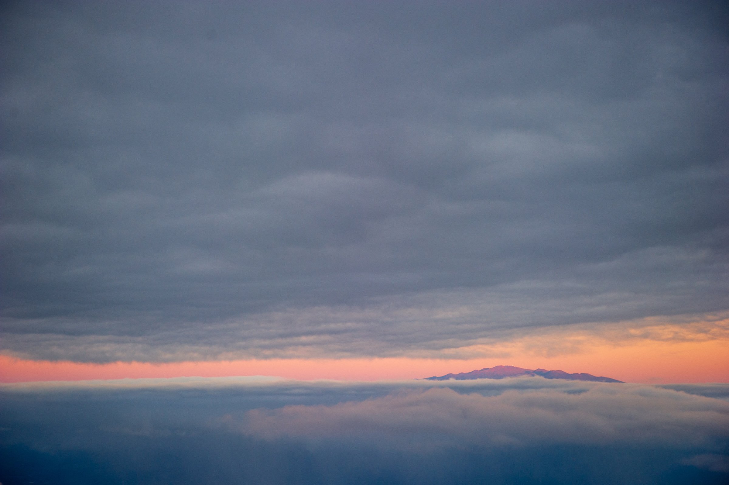 Mauna Kea at dawn through the clouds.