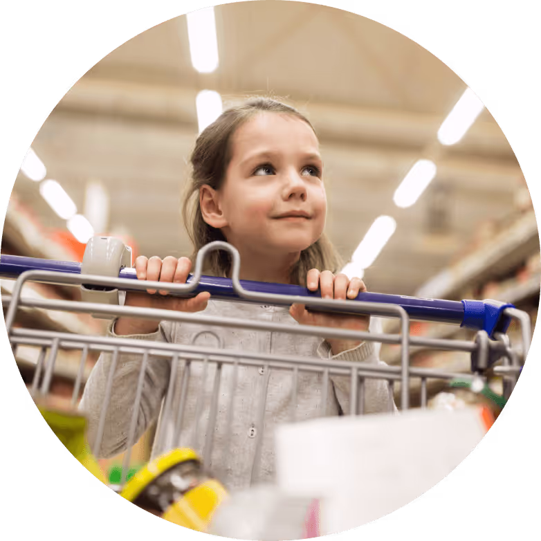 Child pushing a shopping trolley through a shop