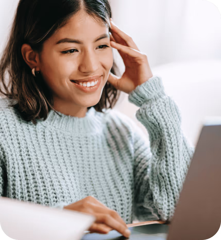 Woman smiling while working on a laptop