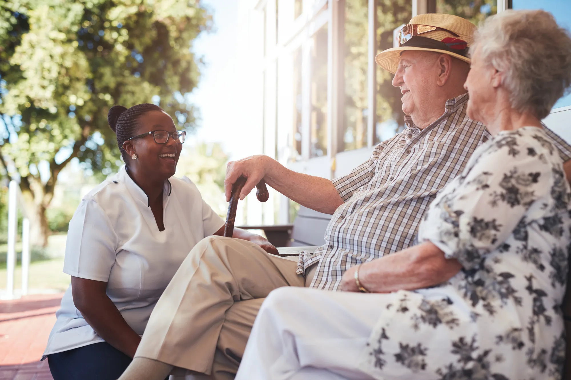 home care lady with elders on a bench