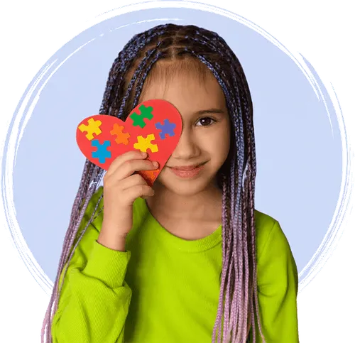 a young girl holding a heart shaped puzzle piece