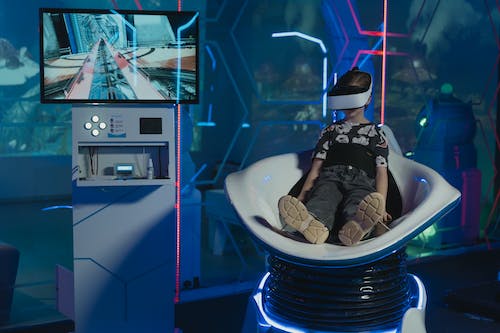 Free Child Sitting on a VR Simulator Ride Stock Photo