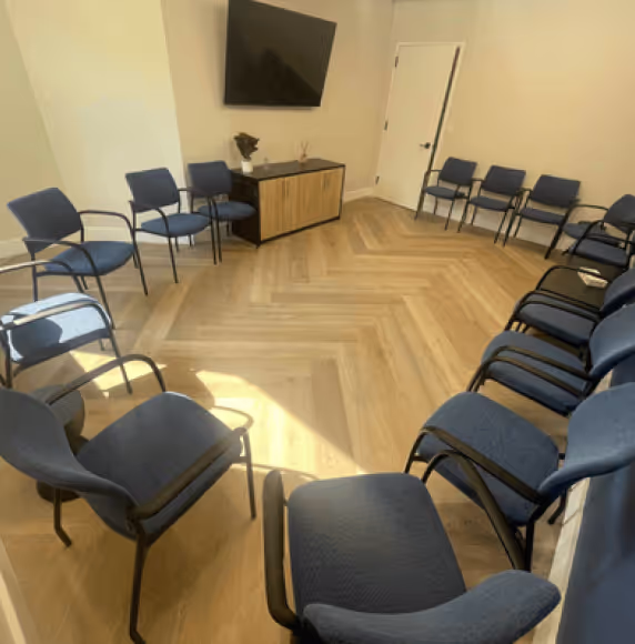 a room filled with blue chairs and a flat screen tv