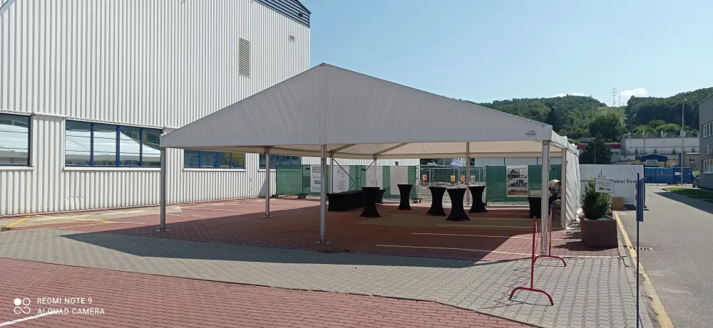 Párty stan 10x20 m u průmyslové haly s koktejlovými stoly — firemní akce Berger Group
