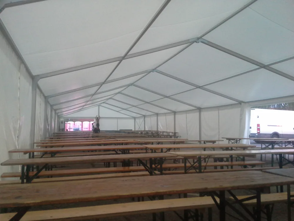 Interiér párty stanu 10x25 m s řadami pivních setů — velká venkovní akce Berger Group