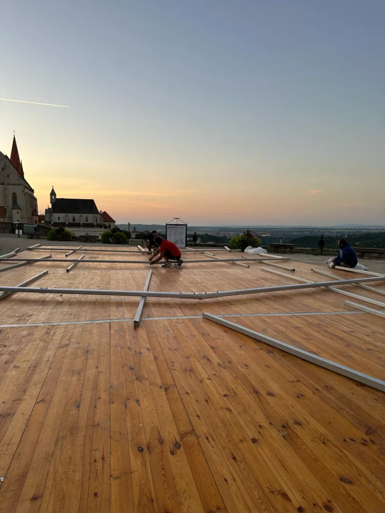 Montáž lakované dřevěné podlahy při západu slunce u kostela — Berger Group