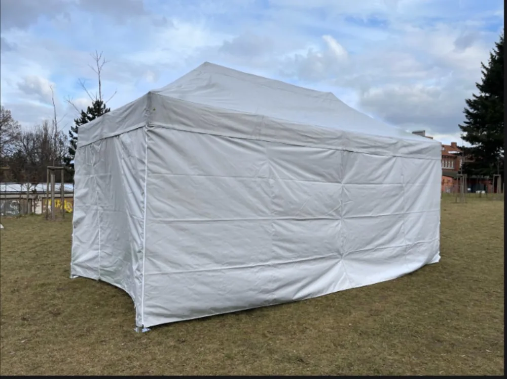 Nůžkový stan 8x4 m bílý s bočními stěnami na trávníku