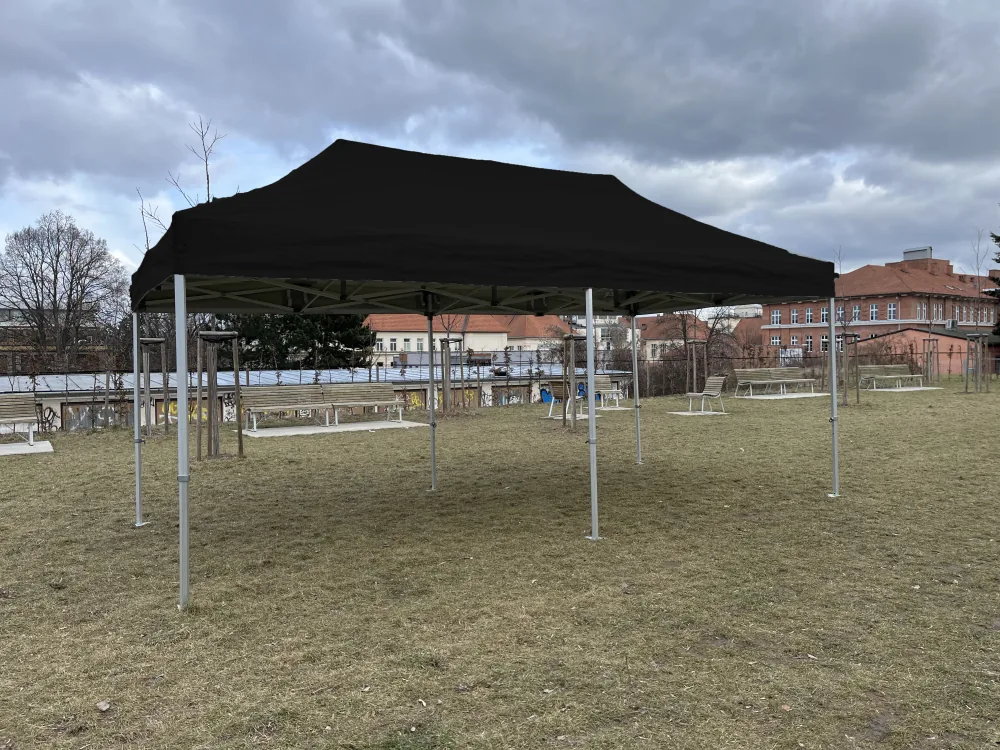 Nůžkový stan 8x4 m černý bez bočních stěn na trávníku – pohled z boku