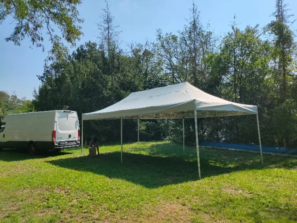 Nůžkový stan 3×6 m bílý bez bočních stěn postavený venku na trávníku
