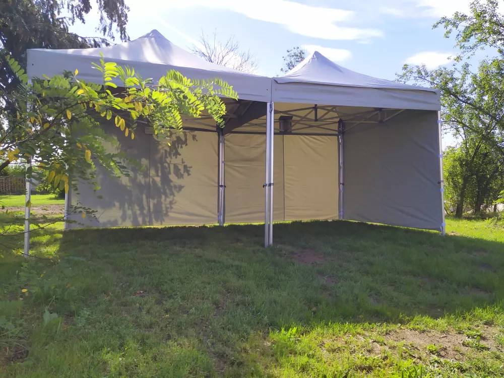 Šedý nůžkový stan 5×5 m s bočními stěnami a zipovým vchodem na trávníku