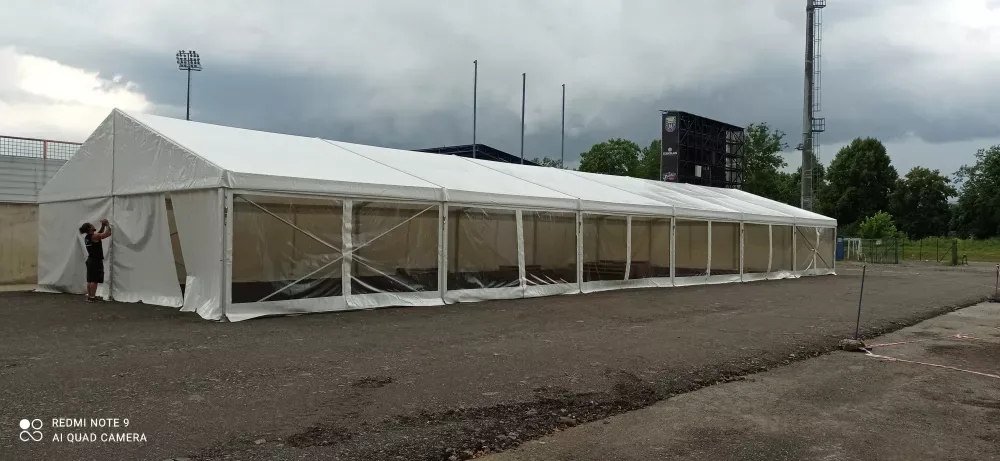 Párty stan 10x30 m při instalaci u sportovního stadionu