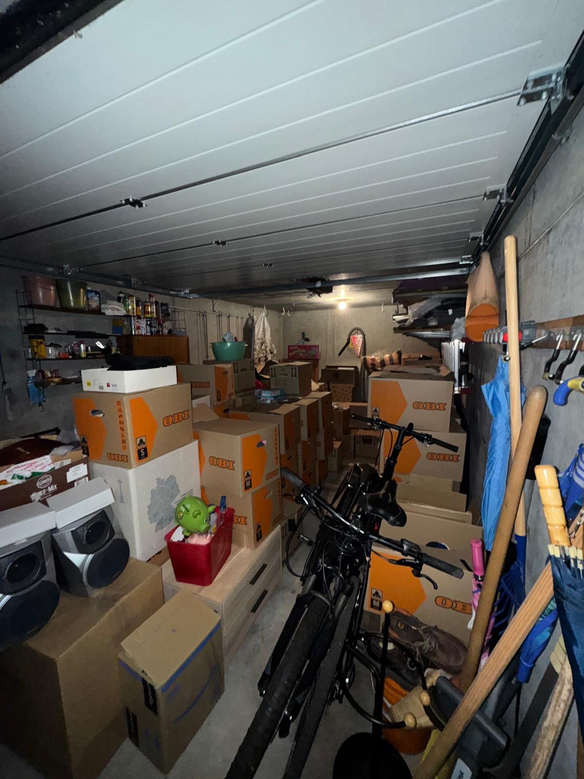 Construction worker in a hard hat and yellow safety vest pressing a fire alarm button while speaking into a walkie-talkie.