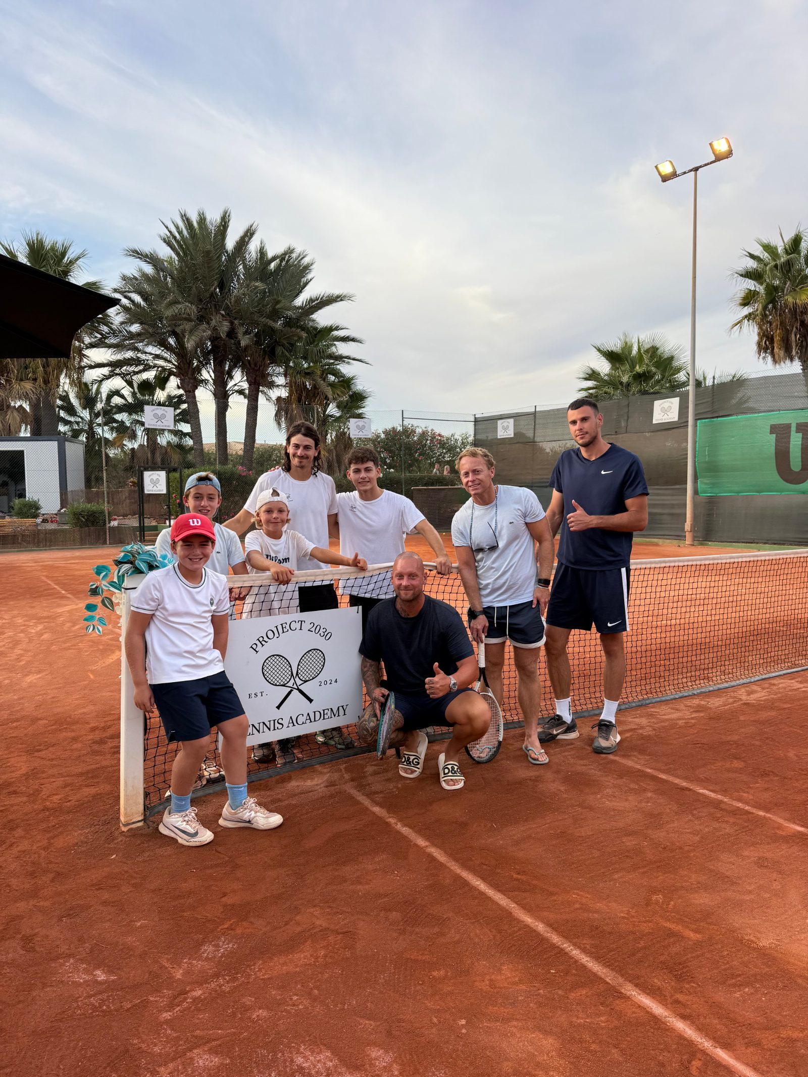Tennisgruppe auf dem Sandplatz