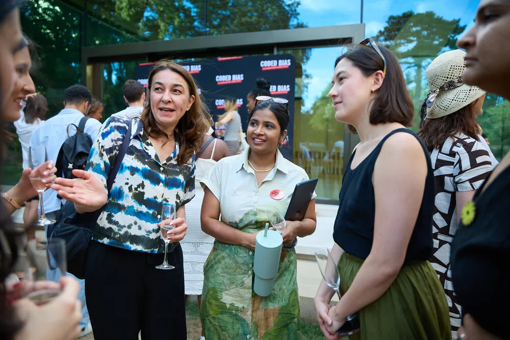 Group networking at outdoor reception - attendees in animated conversation