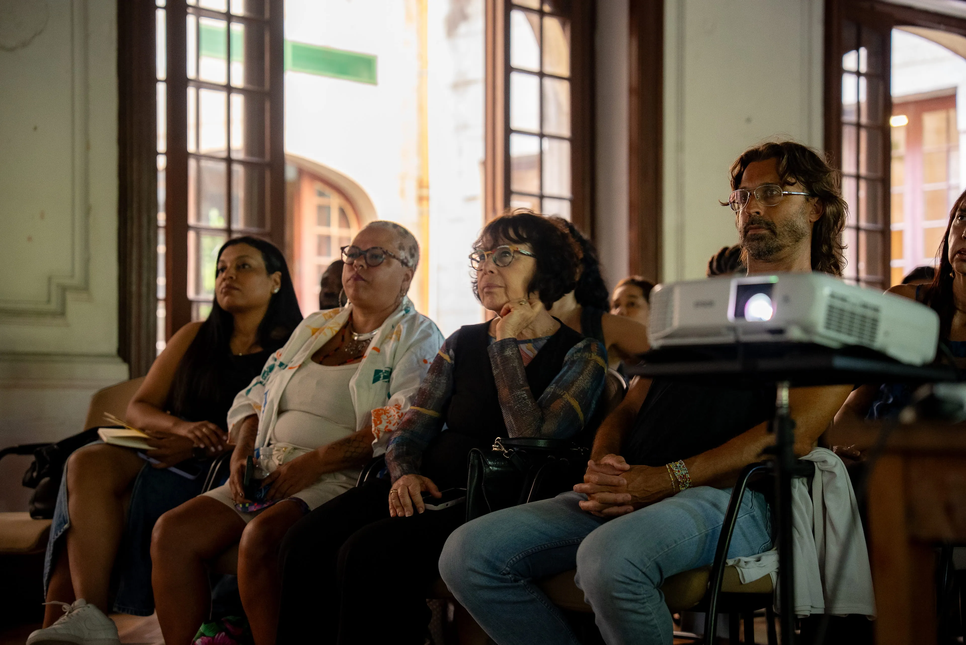Front-row audience members seated near the projector at the Rio Coded Bias screening event