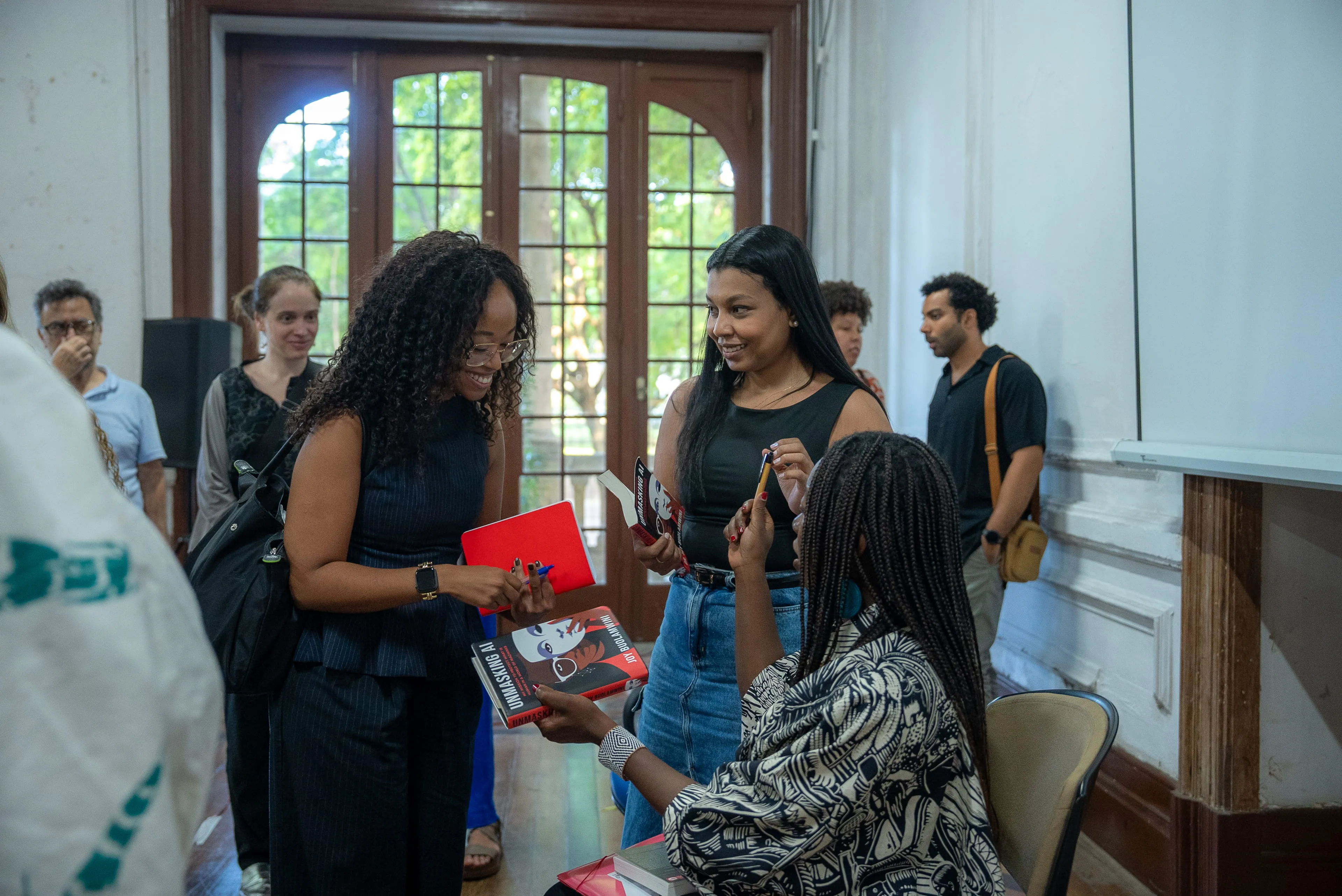 Attendees gathered around a book signing chair after the Rio Coded Bias screening event