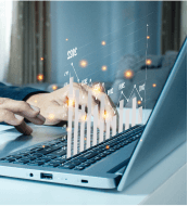 Hands typing on a laptop with a digital overlay of a bar graph and data points.