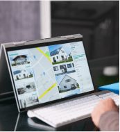 Person using a laptop to view real estate listings on an interactive map.