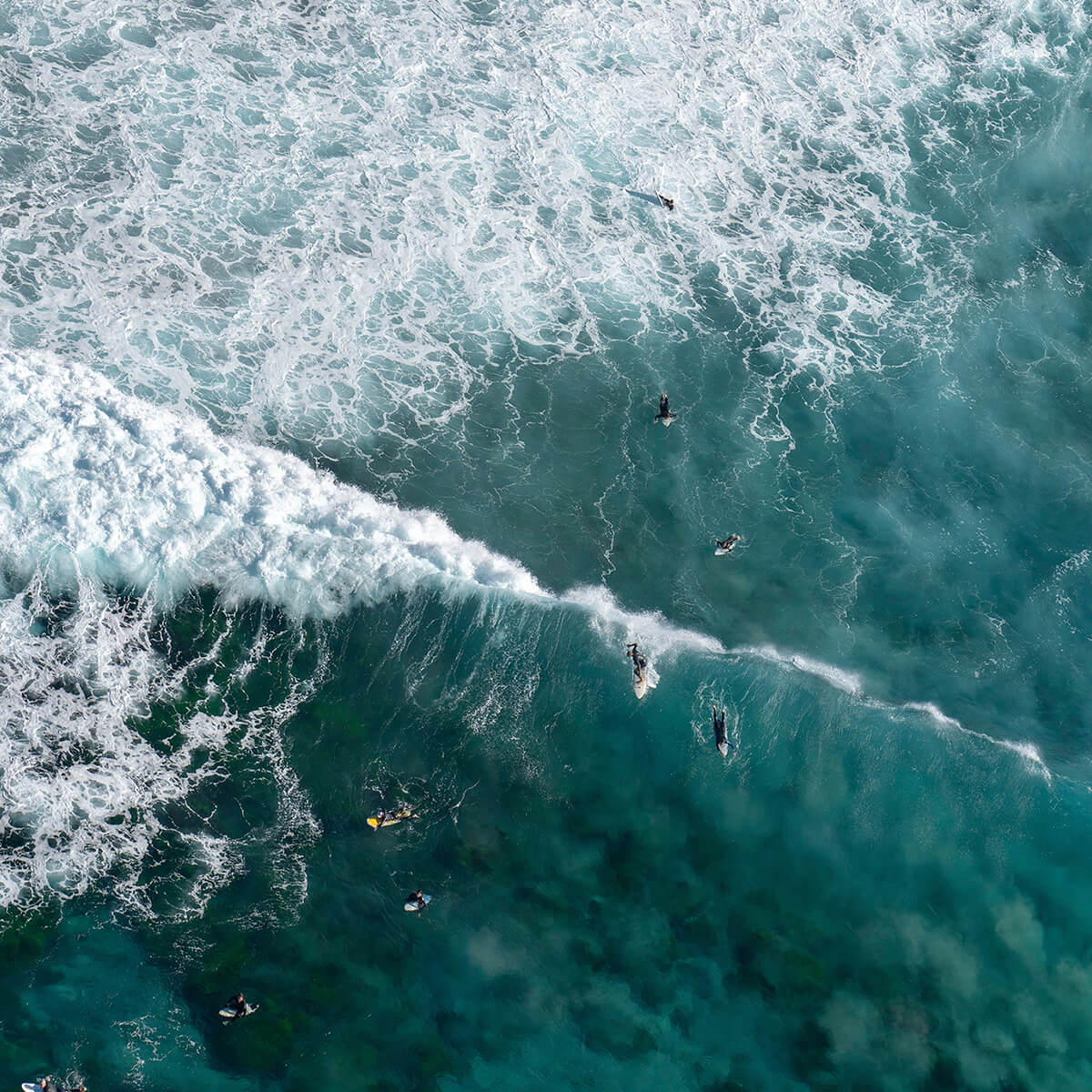 Aerial view of ocean with surfers