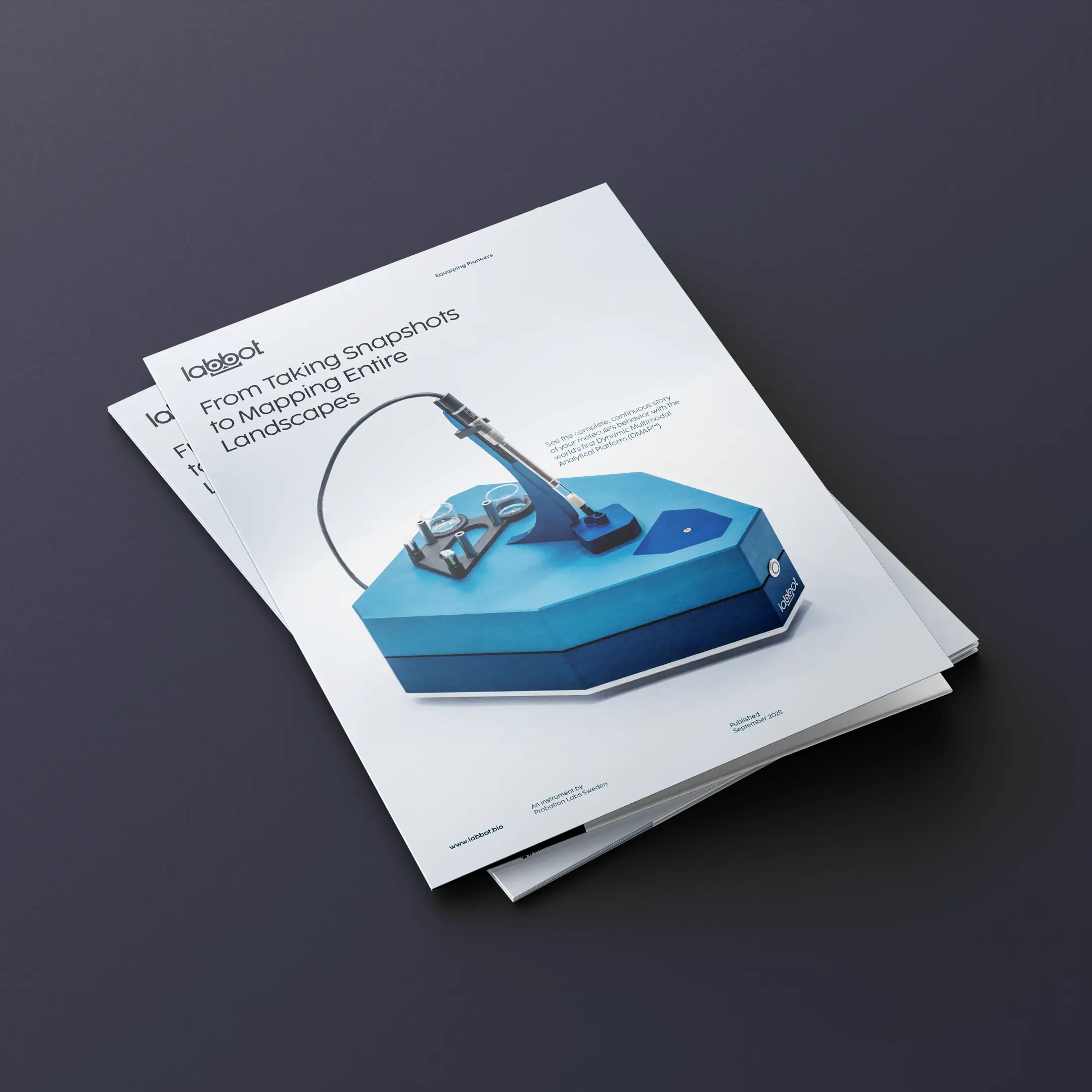 A stack of Labbot brochures placed on a navy table.