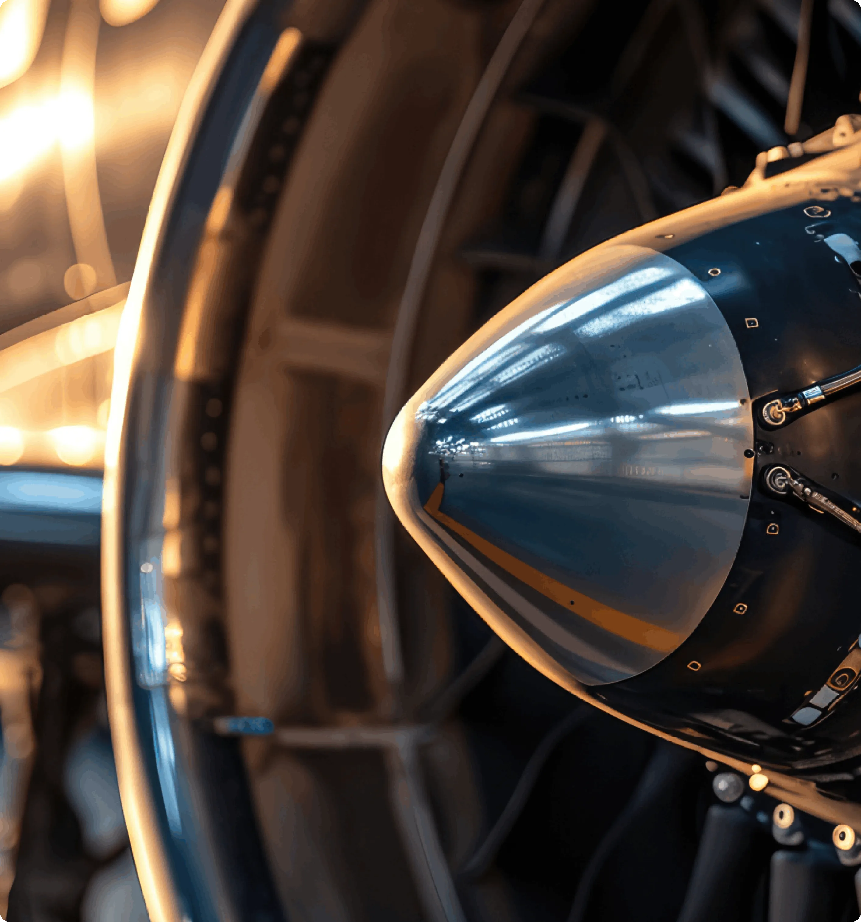 Close-up of a metallic aircraft propeller spinner and blades with light reflections.
