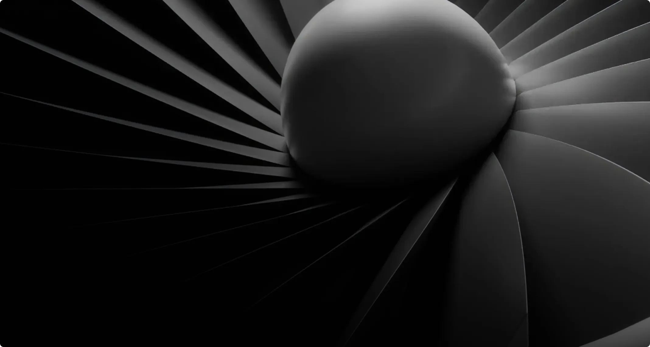 Close-up of dark, curved, fan-like blades radiating from a central spherical hub, resembling a turbine or fan.