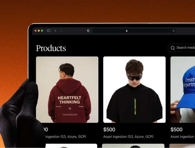 Hand holding a tablet displaying a product page with hoodies priced at $500 and different text designs.