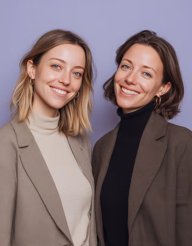 Two professionally dressed women standing together, representing leadership and collaboration in modern recruitment.