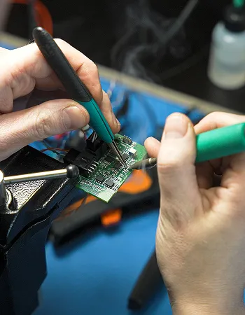 Technician soldering a circuit board for SkyTEM equipment