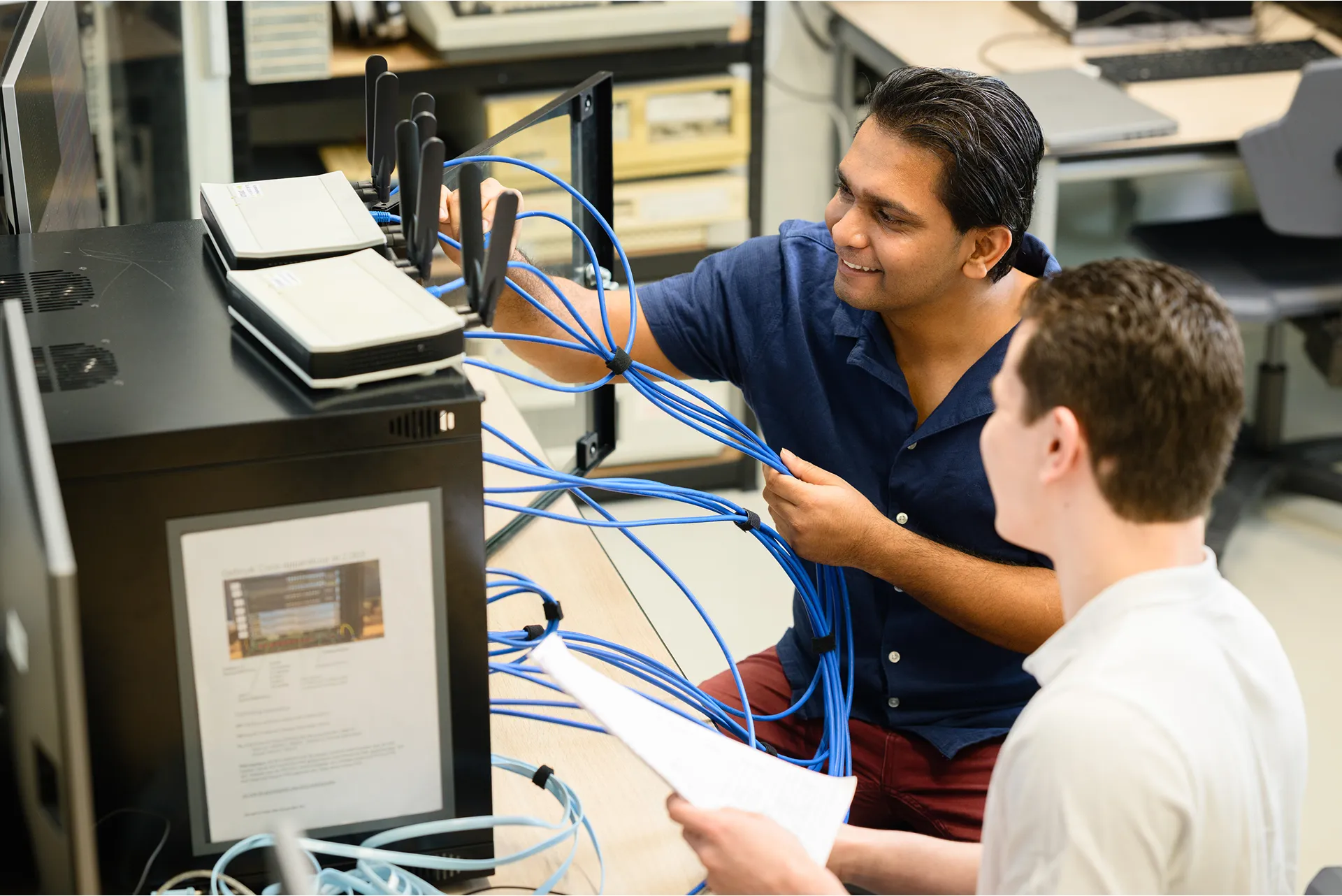 employee plugs cables into device