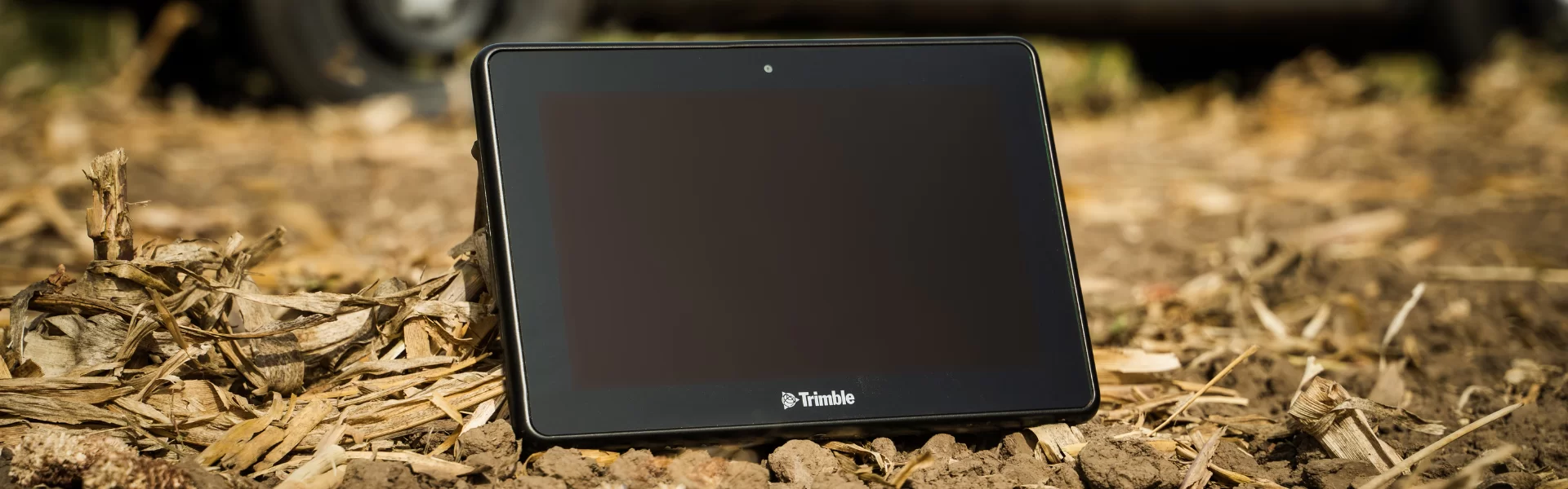 Таблет Trimble, поставен на почва с остатъци от растителност.