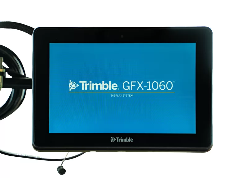 Монитор на дисплейна система Trimble GFX-1060 с черна рамка и син екран.