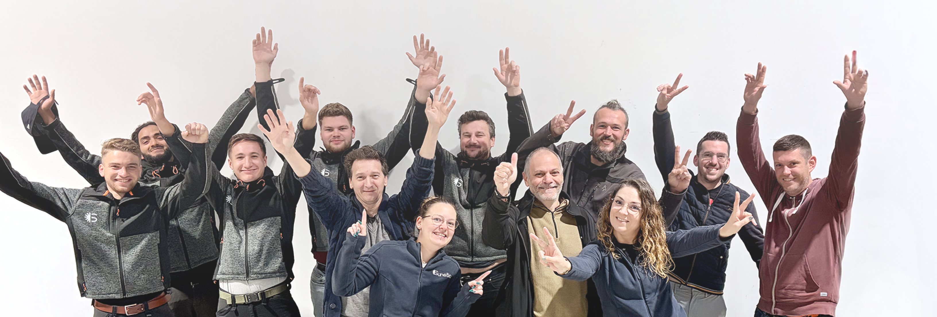 Une photo de l'équipe SUNSTICE qui lève tous les bras et sourient
