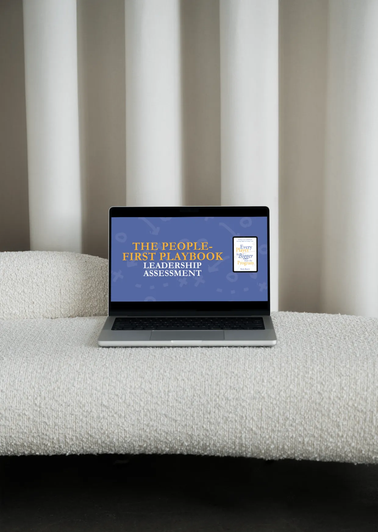 Laptop on textured beige sofa displaying a screen titled 'The People-First Playbook Leadership Assessment' with a small image of a book cover titled 'Every Player is Bigger than the Program.'