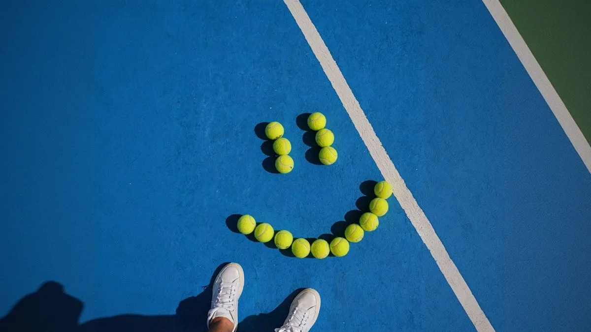 A tennis court with a smiley face made out of tennis balls.