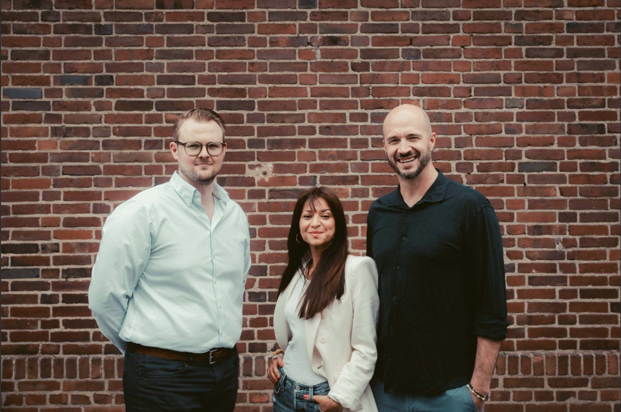 Team von Puentes Real Estate vor Backsteinwand.
