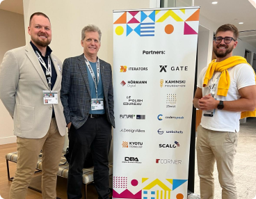 Kamil Zawadzki, Thom Singer and Matt Romanow on Gate Event against the sponsor backdrop